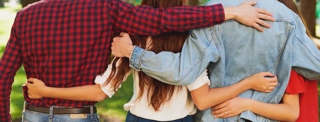 Group of people arms entwined in group hug